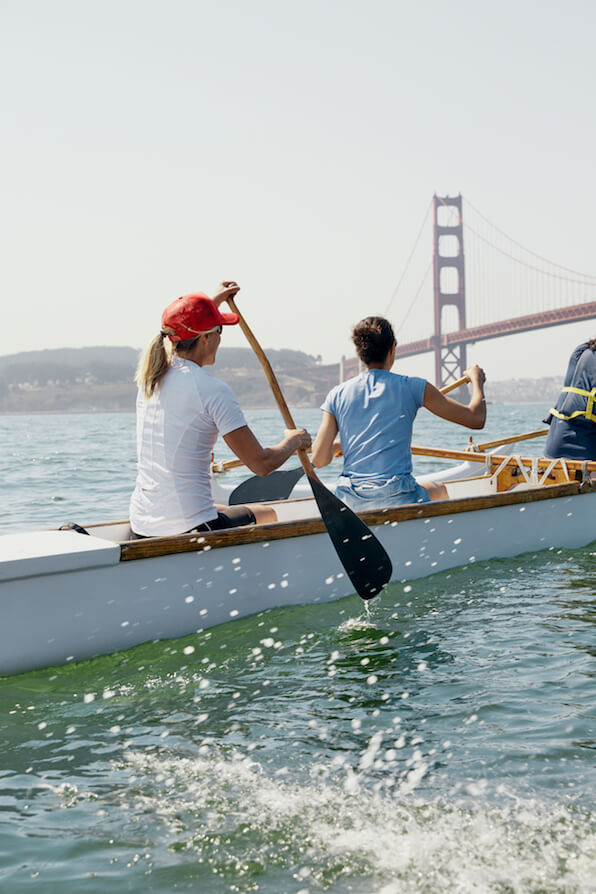 Un grupo de personas remando una lancha cerca del puente Golden Gate