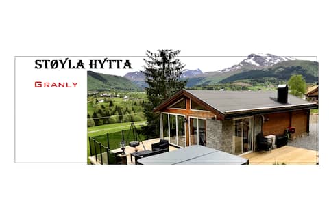 Cozy cabin with covered jacuzzi and mountain view.