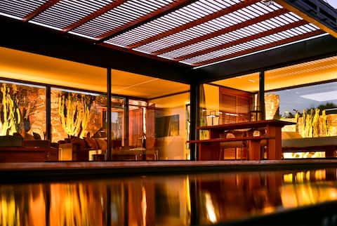 Wake up to nature in this modern glass house.