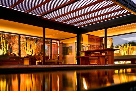 Wake up to nature in this modern glass house.