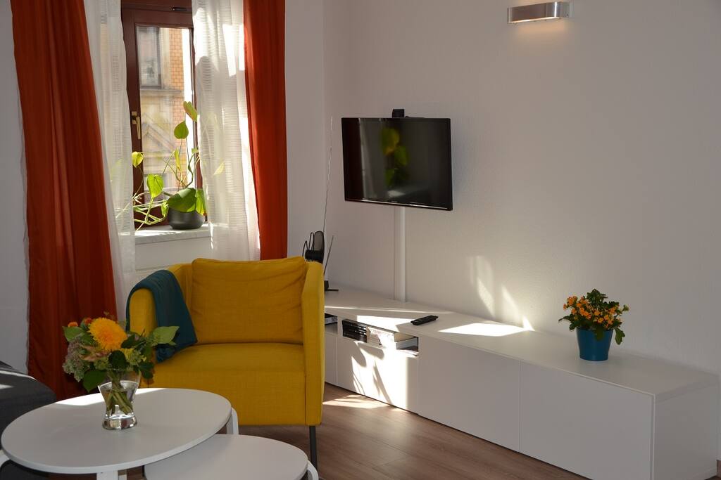 Kuschliges Wohnzimmer mit einem gemütlichen Lesesessel und Flachbild-Smart-TV
