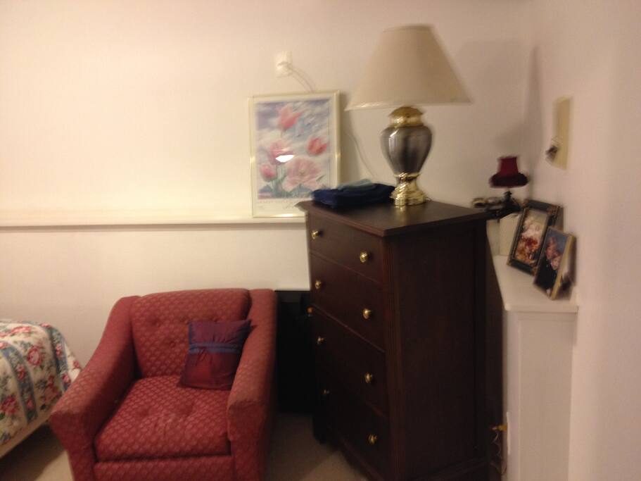 bedroom with chest of drawers and comfy chair