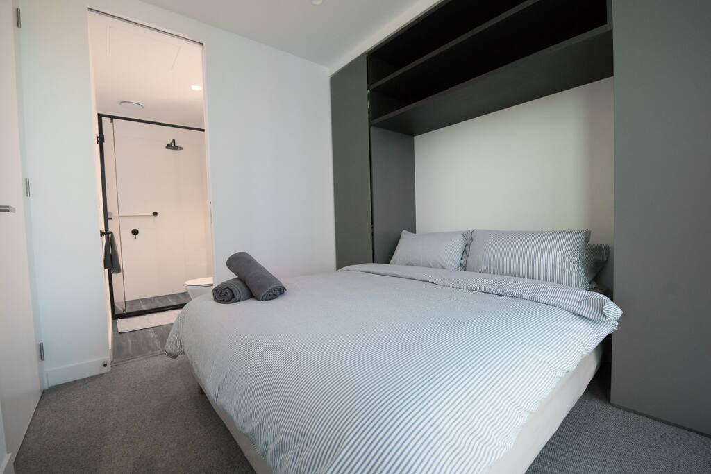 The master bedroom with a queen sized bed & plush pillows.