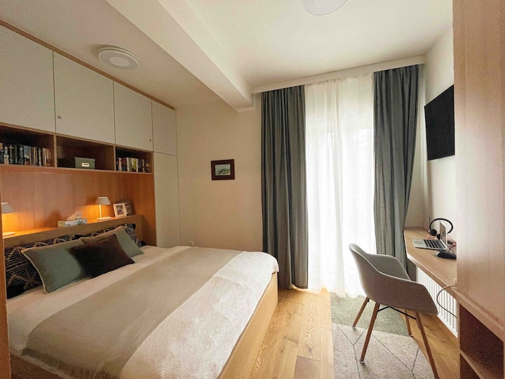 غرفة نوم، مجهزة بالعديد من الكتب الجيدة والتلفزيون. تحتوي مصابيح الطاولة على محطات شحن متكاملة.