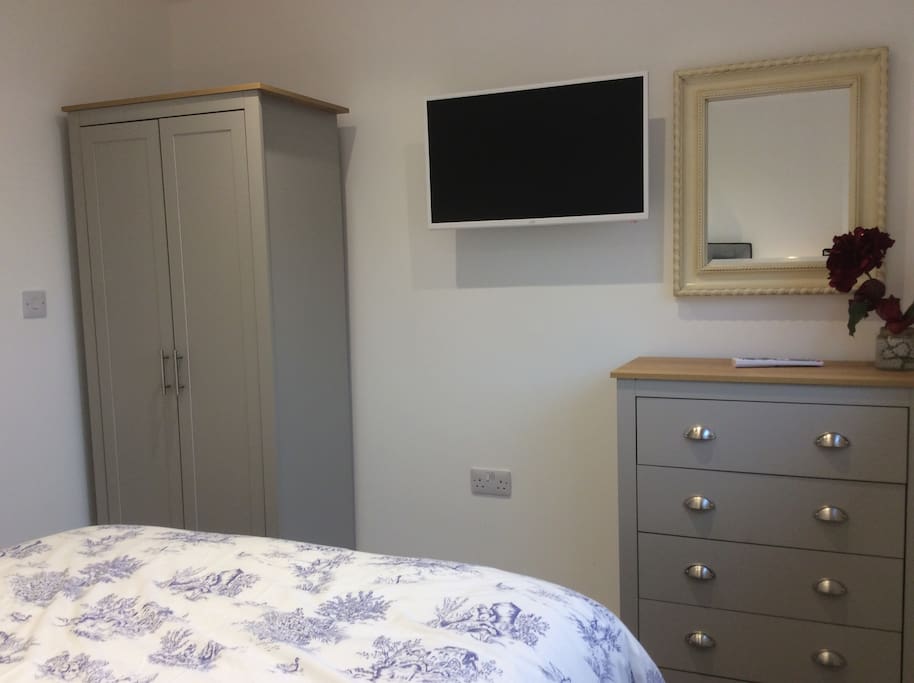 Double bedroom with tv , double wardrobe and draws