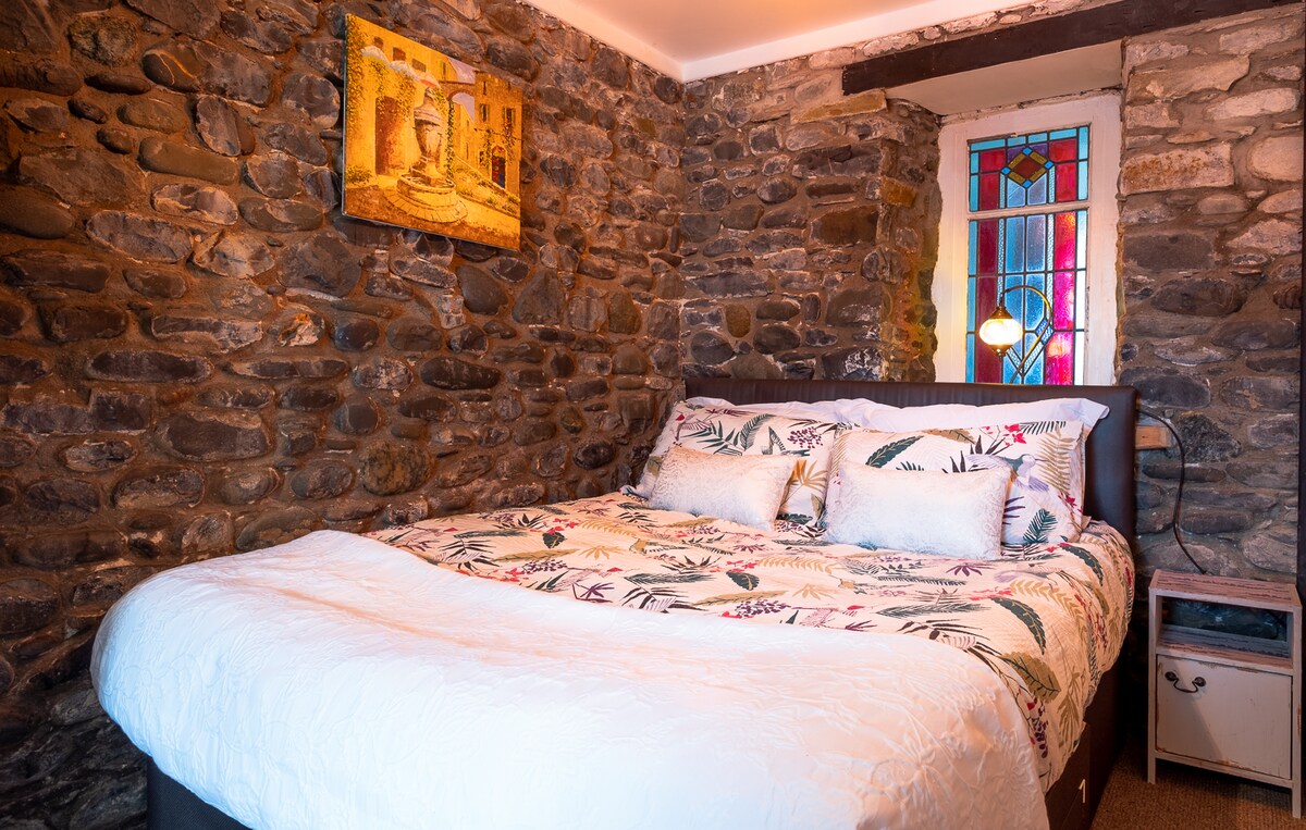 Dormitorio 1: las paredes de piedra tradicionales y una hermosa vidriera dan a esta habitación un montón de características interesantes. Tiene una cómoda cama tamaño king y mucha luz.