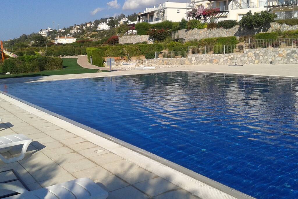 Relax by the large swimming pool with loungers & adjacent kids' pool