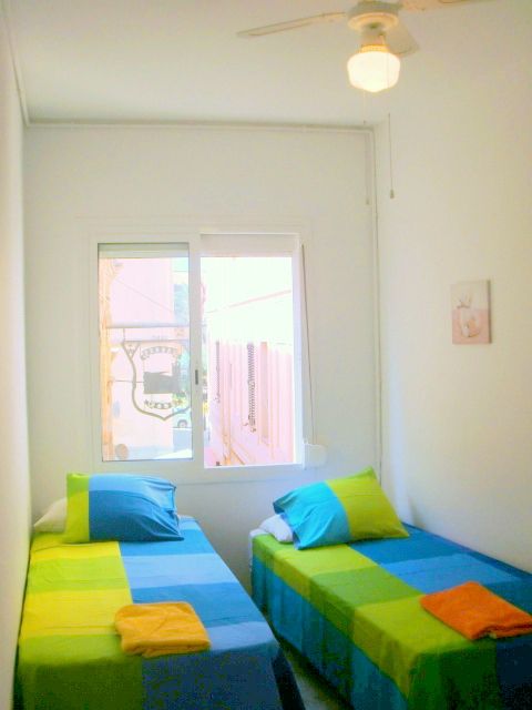 غرفة بسريرين متماثلين ومروحة سقف