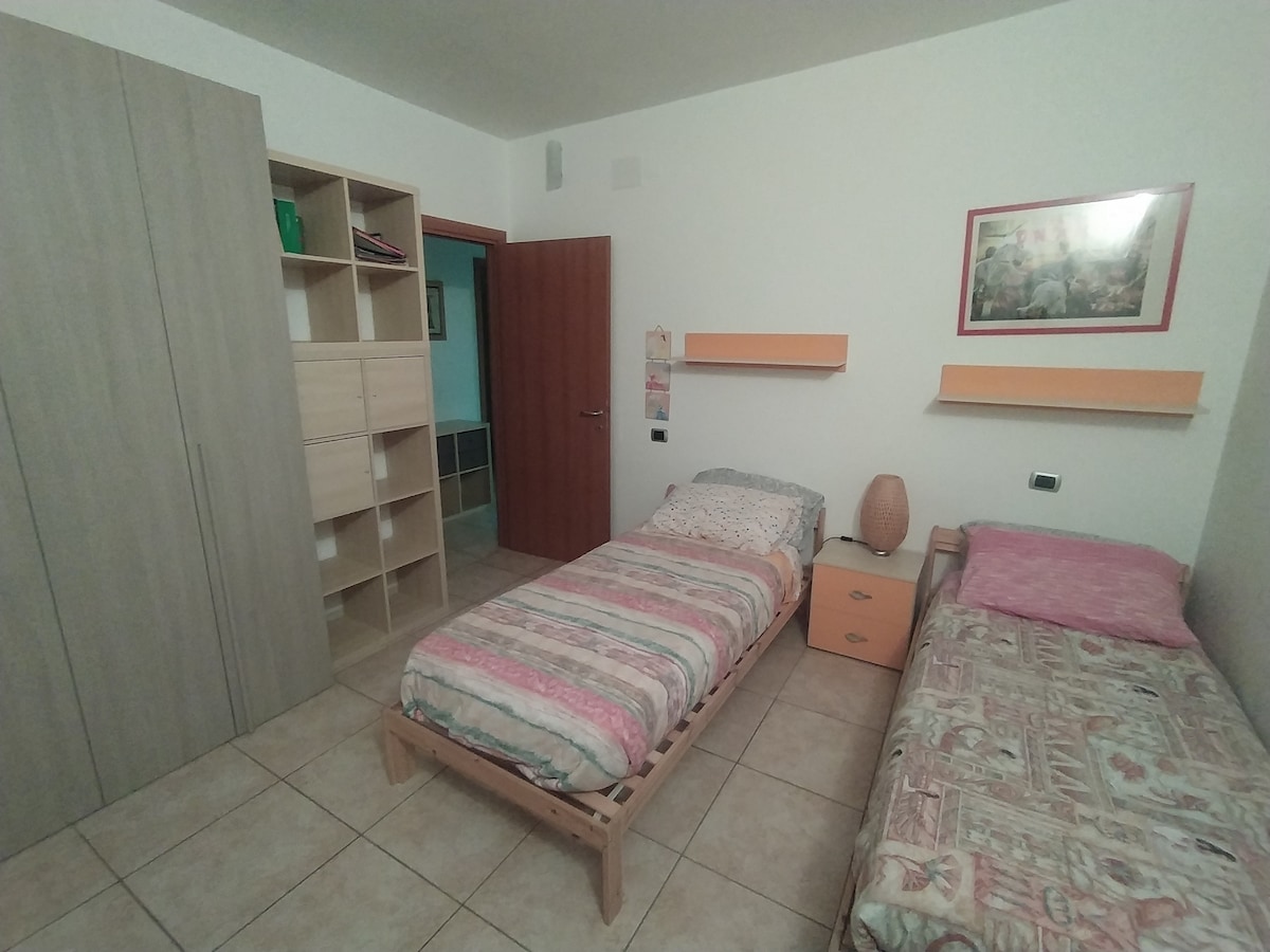 Cameretta. Due letti singoli, armadio e scrivania con sedia 