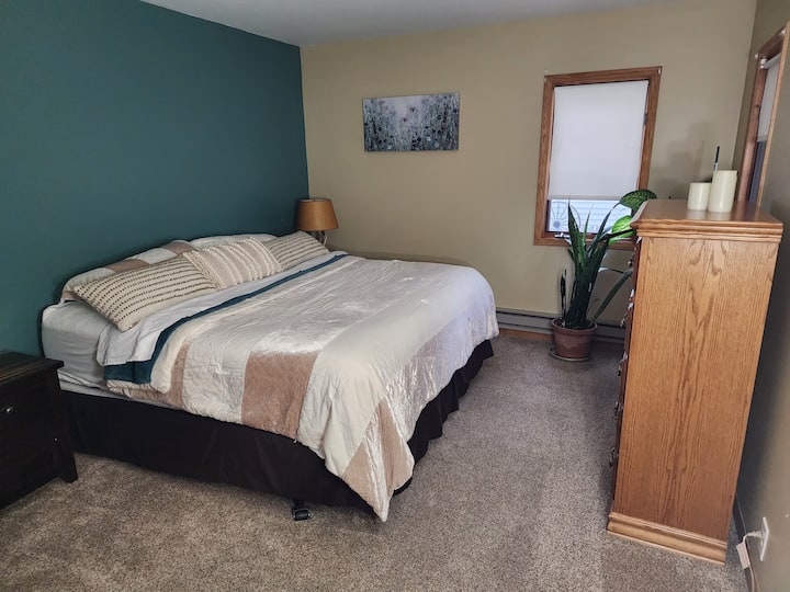 ห้องนอนใหญ่เตียงคิงไซส์ หน้าต่างมองออกไปที่สนามหลังบ้านและริมถนนหน้าที่พัก