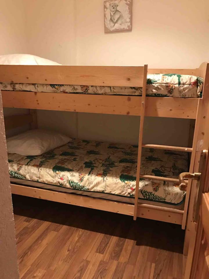 楼下的第三间卧室，配有双层床和窗户