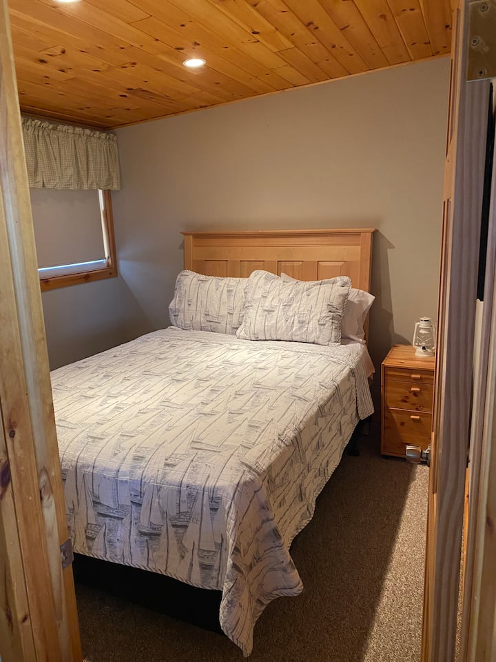 Chambre principale. Lit queen size. Situé au niveau supérieur, accessible dans l'espace de vie principal.