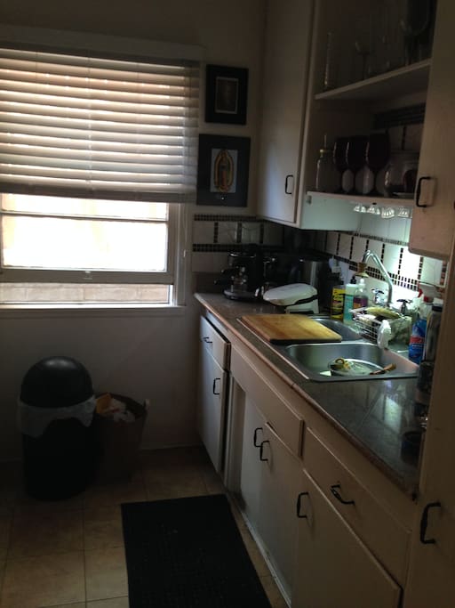 Cute little kitchen with microwave, fridge, gas stove and espresso machine