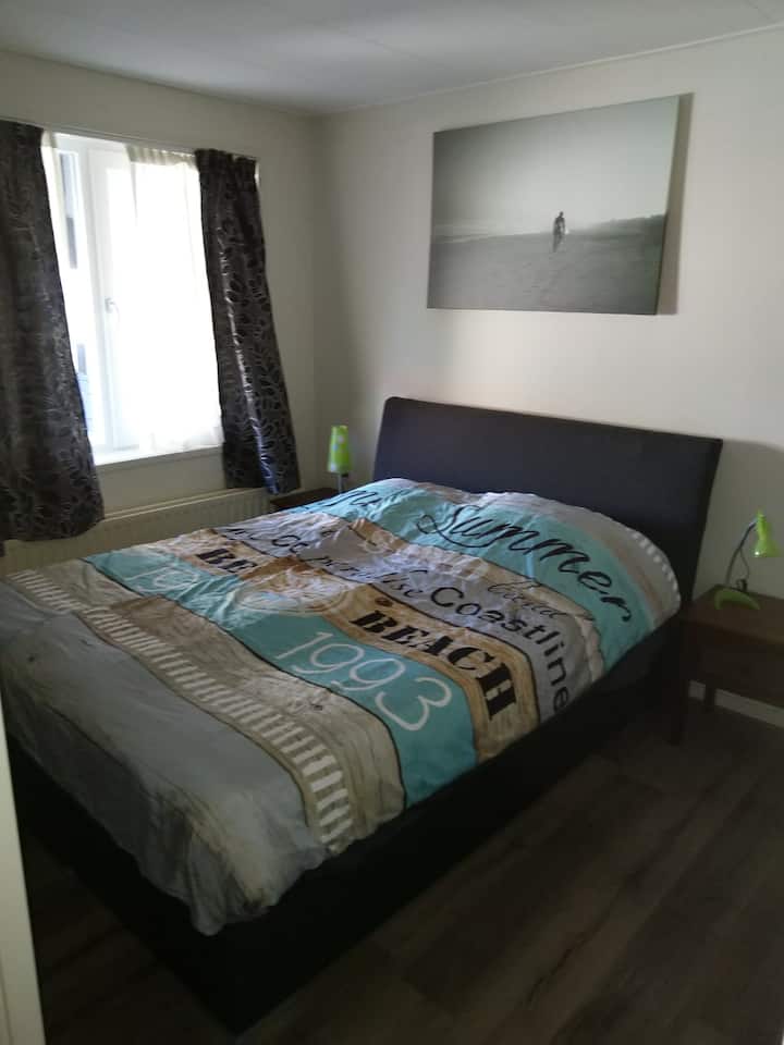 Основна спалня с легло от 210 м, две нощни шкафчета с чекмеджета и осветление.