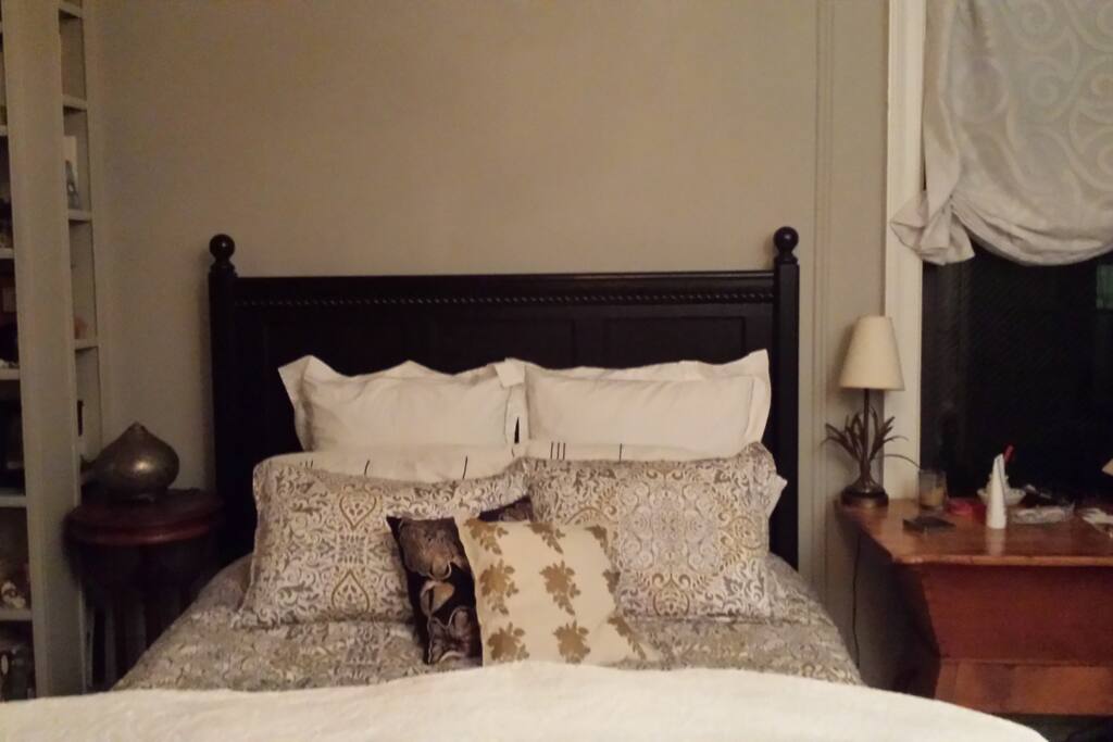 queen size bed with three windows in room