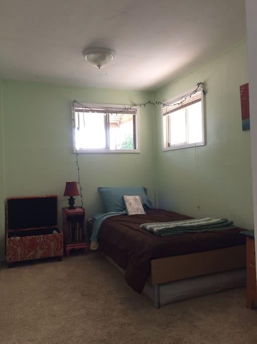 Cozy bedroom with windows on two sides for ample light and breeze.