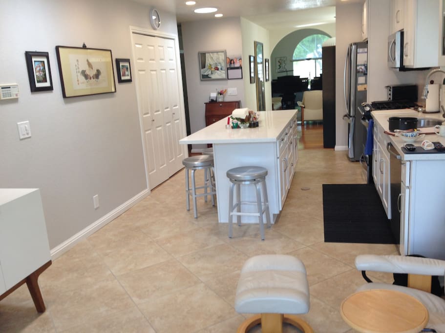 Remodeled kitchen/family room with gas stove, large island, TV and two easy chairs.