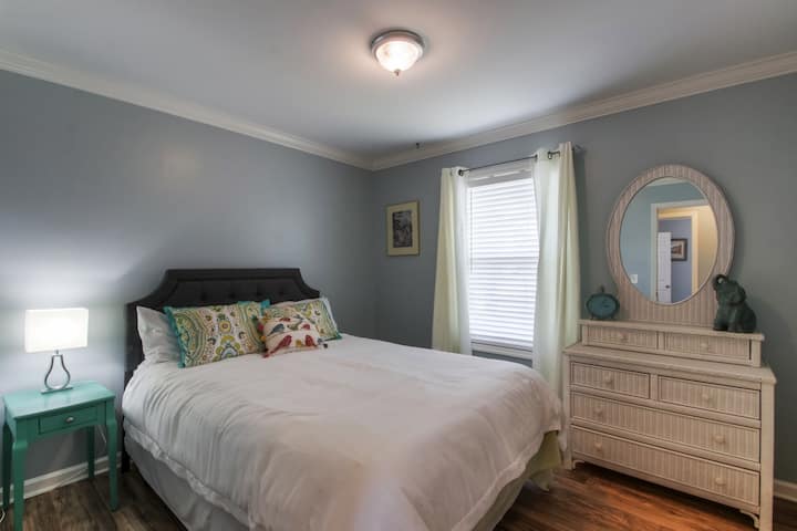Queen bed with vintage wicker dresser. In the closet is a new play-n-pack and high chair if you need them.