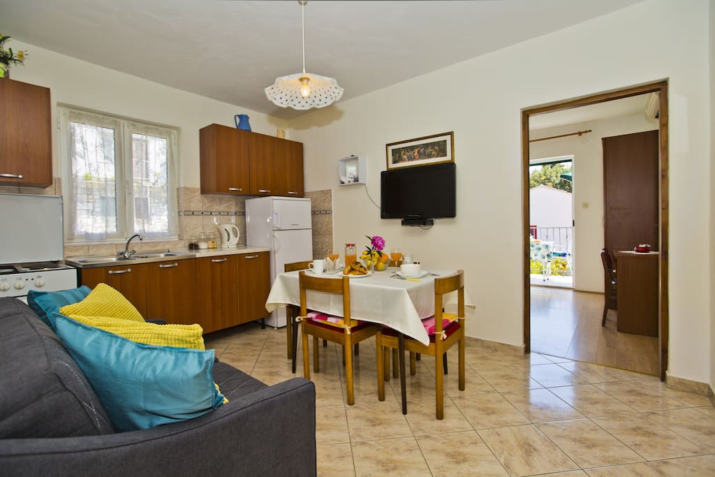 Fully equipped kitchen with a dining table, sofa and SAT/TV