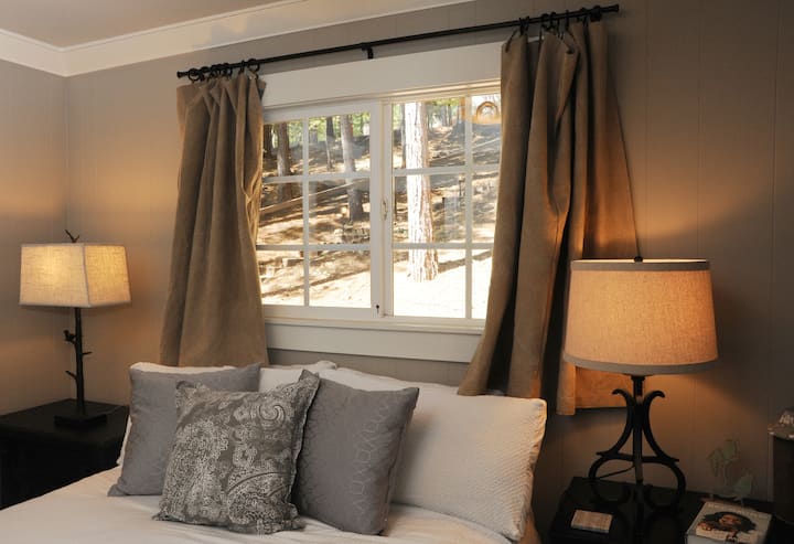 أنت محاط بالأشجار خارج غرفة النوم الرئيسية أيضًا. لذا ، عندما تنظر من النافذة ، هذا كل ما ستراه وأنت تنظر أعلى التل.