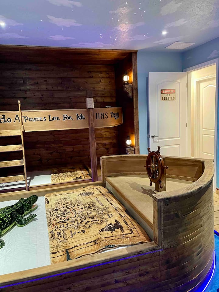 Nunca crezcas y vueles a Neverland en nuestro dormitorio temático de Peter Pan. ¡Esta habitación cuenta con la cama de tamaño completo Jolly Roger del Capitán Garfio atracada a lo largo de las literas gemelas del barco Dream & Magic! Mira películas en el televisor inteligente 4K de 55 pulgadas con estrellas centelleantes sobre ti.