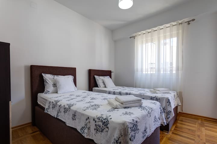 تم تأثيث الغرفة الأخرى بسريرين فرديين ولكن مريحين. 