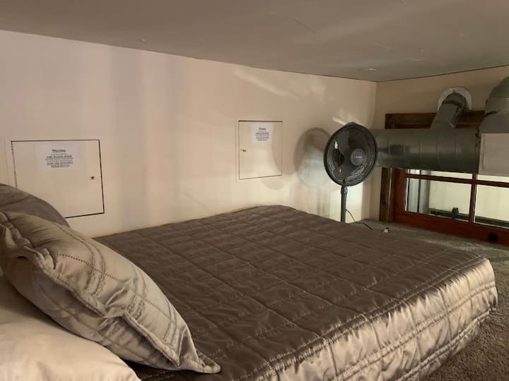 Deze slaapruimte op de zolder bevindt zich boven de ladder in de hoofdslaapkamer en kijkt neer op de hoofdslaapkamer eronder. 