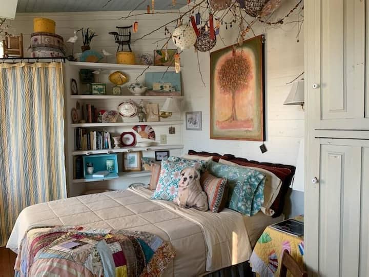 The bedroom with its unusual ceiling decor is warm and inviting.   You can see the river when you wake up in the morning and go to sleep at night out of the door to the river porch.  Large empty closets and a chest can house luggage and clothing. 