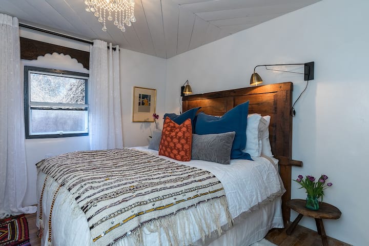 Lit queen size avec draps de luxe et mobilier et luminaires de luxe partout.