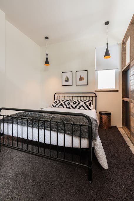 Queen sized bed with touches of luxury and local artworks