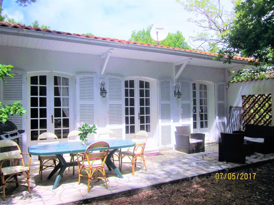 1° TERRASSE...BIENVENUE à la villa "ETOILE DE MER" avec sa terrrasse plein pied COTE FORET avec les 3 porte fenetres du living donnant accés direct sur la salle à manger ext et chaises bistrot, barbecue