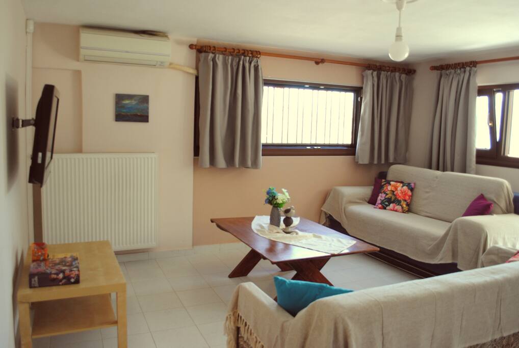 The living room has a second sofa and a 32'' flat screen TV