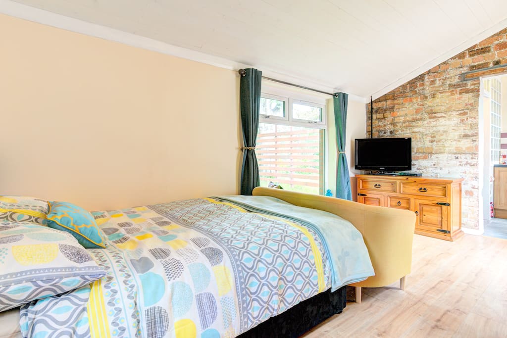 The main room with double bed, sofa, tv