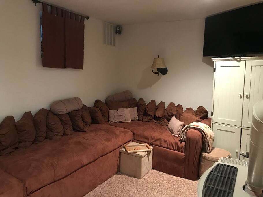 Family Room with large wrap-around couch made with twin mattresses. Very comfortable for two people to sleep!