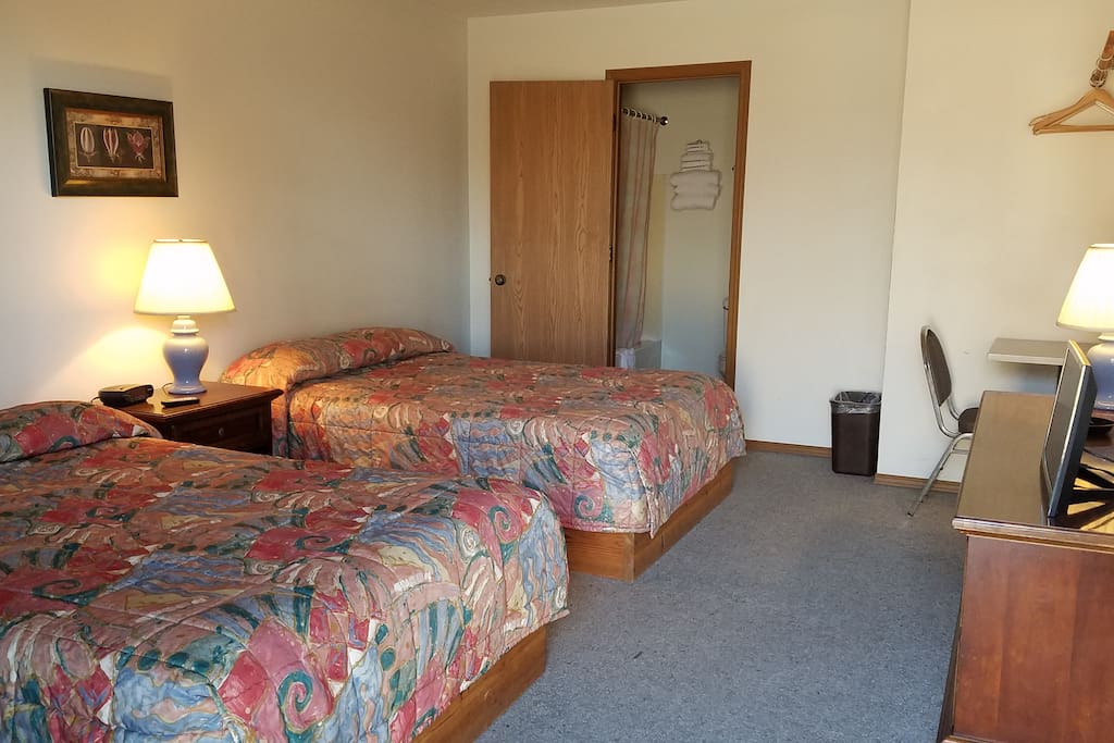 Room 1 with two full-size beds, private entrance, bath, and TV