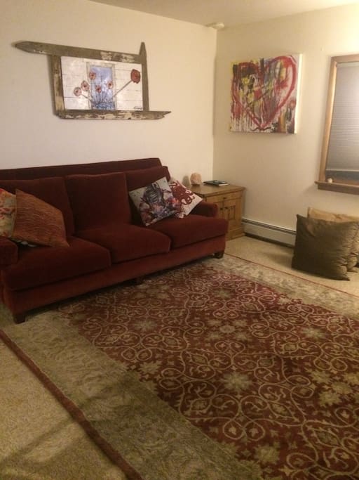 Living room with comfy couch, soft rug and lots of pillows.