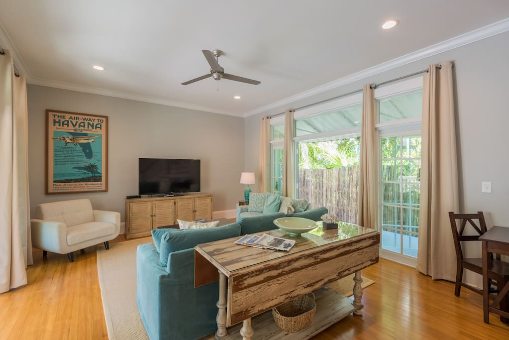 Bright airy and spacious living room with french doors on both sides leading to private patios.