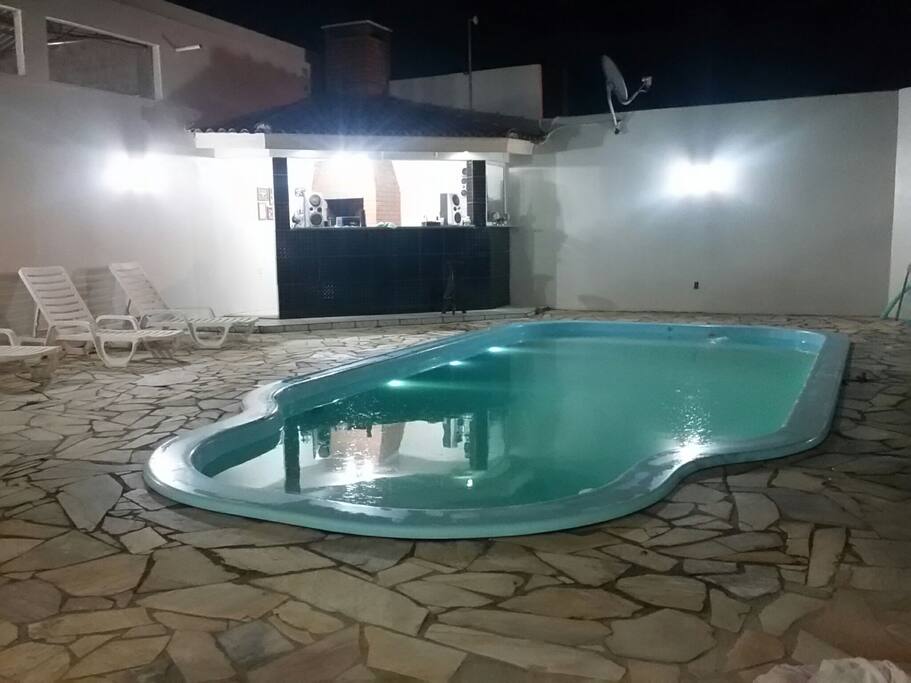Piscina e Quiosque iluminados a noite.