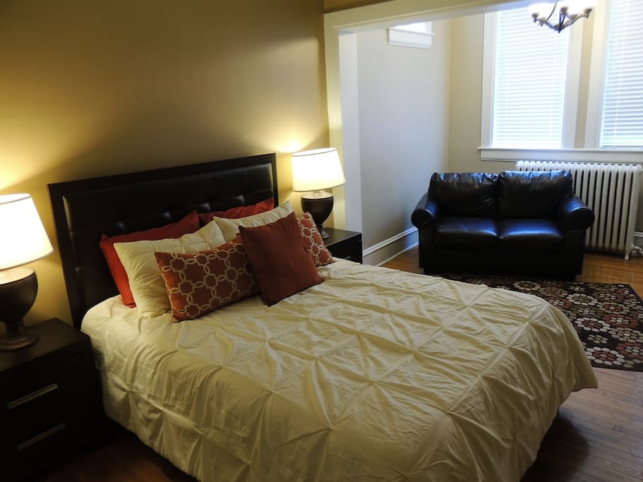Queen bedroom with sitting area illuminated by the windows on the tower at the top of the Twin Mansion