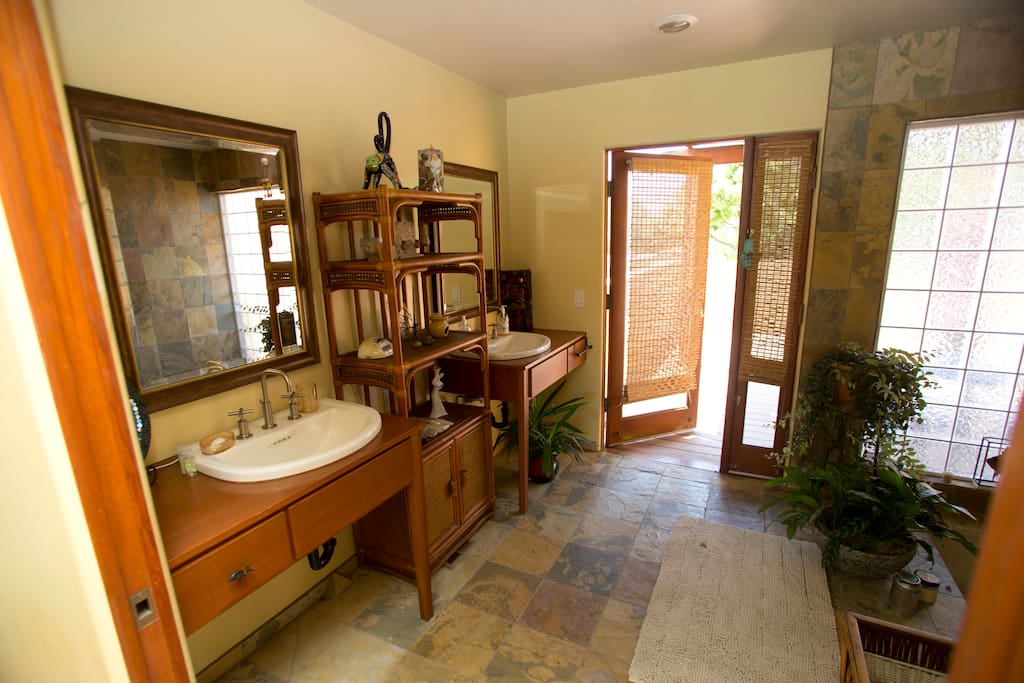 Sliding pocket door opens and you are in the bathroom. Two sinks and slate floors. Door you see is to the deck.a