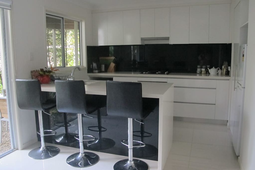 Kitchen equipped with fridge, microwave, oven, toaster, jug, cutlery, glasses, etc.