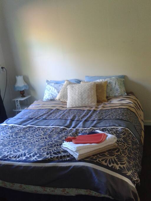 Queen size bed in private room with wardrobe.