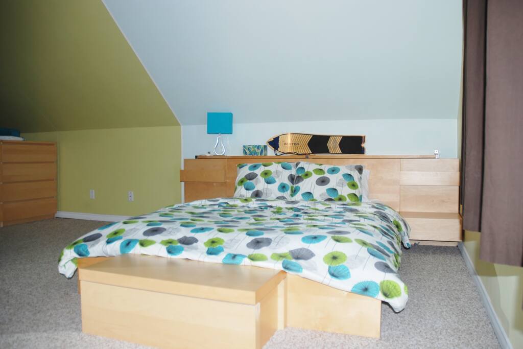 Queen mattress on bed frame. Main sleeping area.