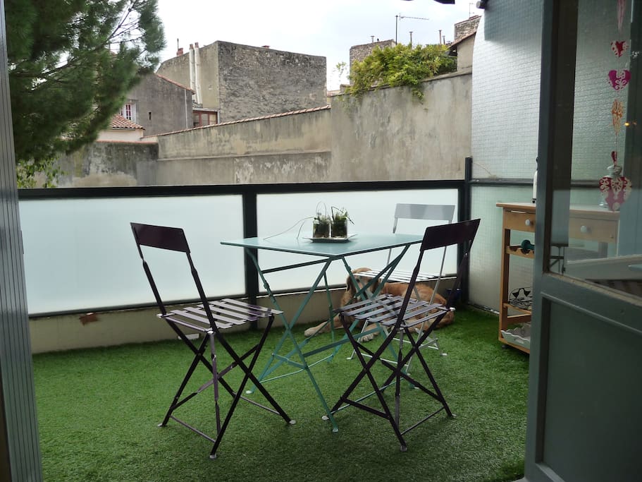 La terrasse est bien agencée avec chaises et tables pour profiter du moindre rayon de soleil