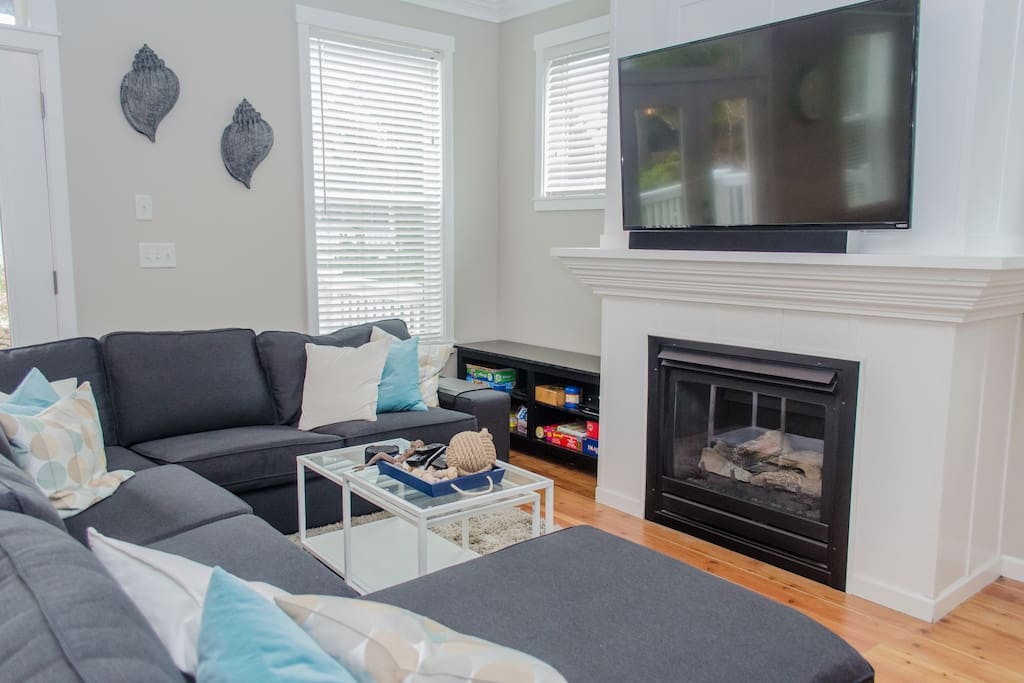 Living room with flat screen TV and a cozy fireplace.