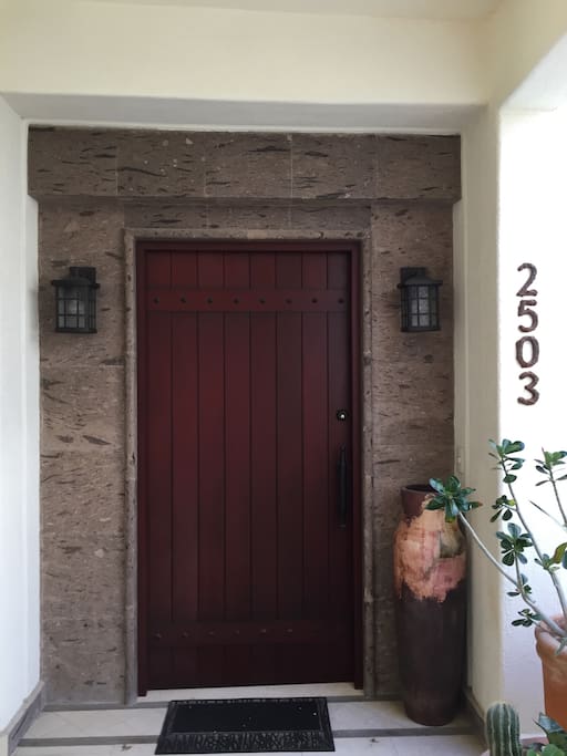 Front door, immediately to the left of the elevator.