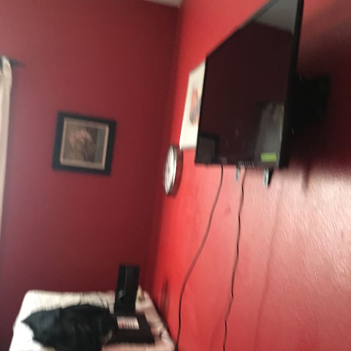Queen size bed in a spacious room with a large window and a TV in the room. A very spacious closet in the room for guest' s convenience.