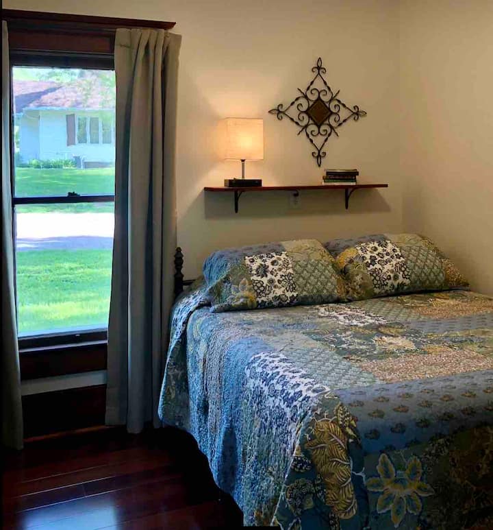 La salle de bain attenante dispose d'un lit Queen Size antique avec un nouveau matelas moelleux moyen, une literie de luxe, une commode en acajou antique, des draperies occultantes et un ventilateur de plafond