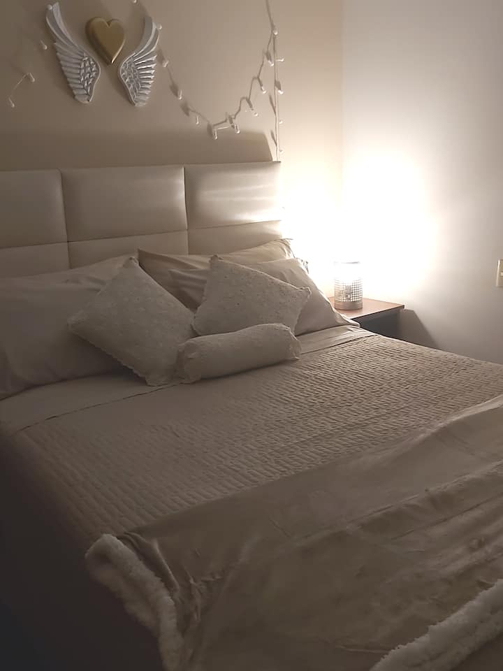 El dormitorio posee una cama queen y una iluminación decorativa sumamente acogedora y relajante, que lo atrapa para un largo descanso.