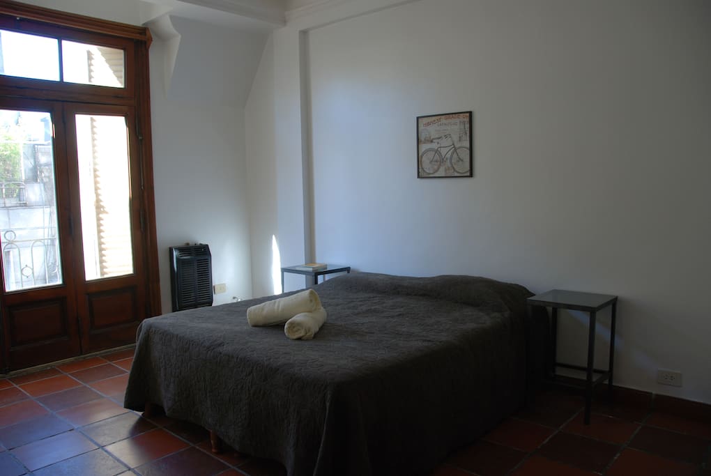 Luminoso dormitorio con ventanal y balcón, cuenta con un gran ropero, aire acondicionado y calefacción.